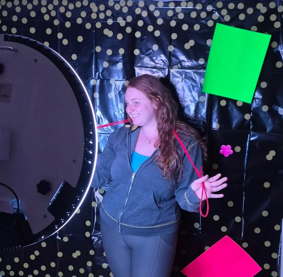 Guest using colourful props in front of the SprintXP photo booth