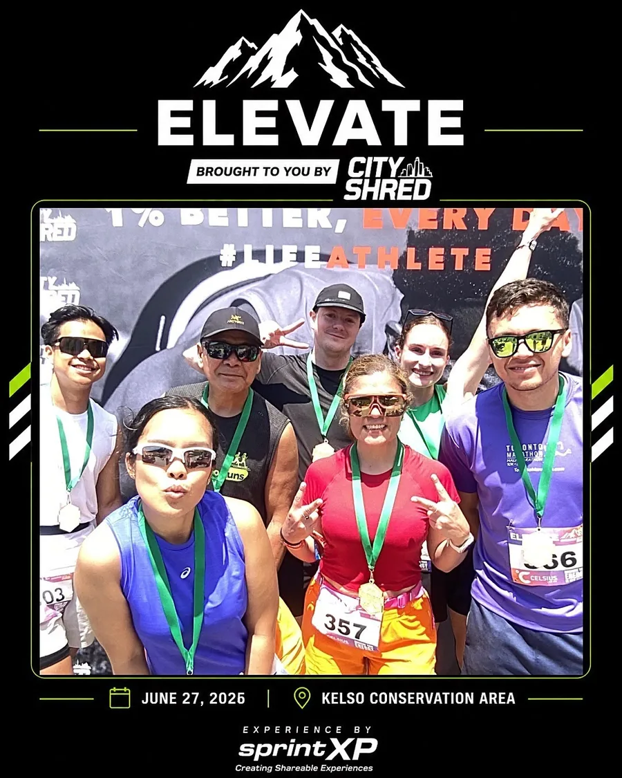 Group of runners posing inside a branded event frame